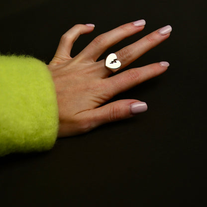 Broken heart ring on female hand, nail polish